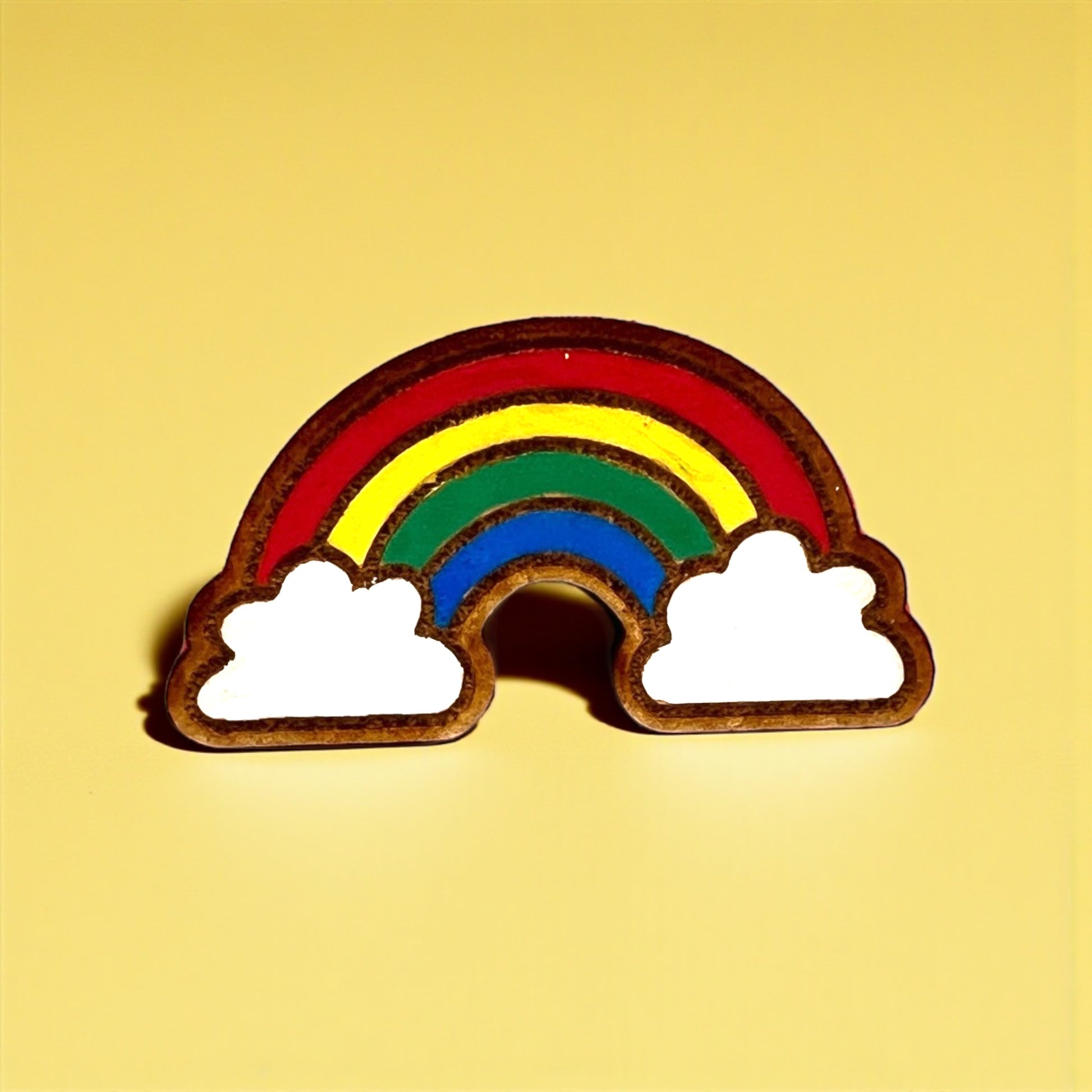 Rainbow-shaped object with clouds on a yellow background