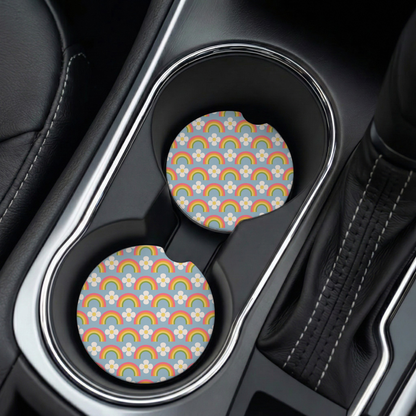 Car cup holder with two colorful patterned coasters on a black leather interior.