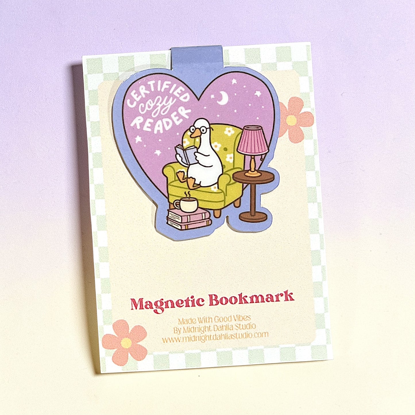 Magnetic bookmark with cartoon duck reading a book on a checkered background