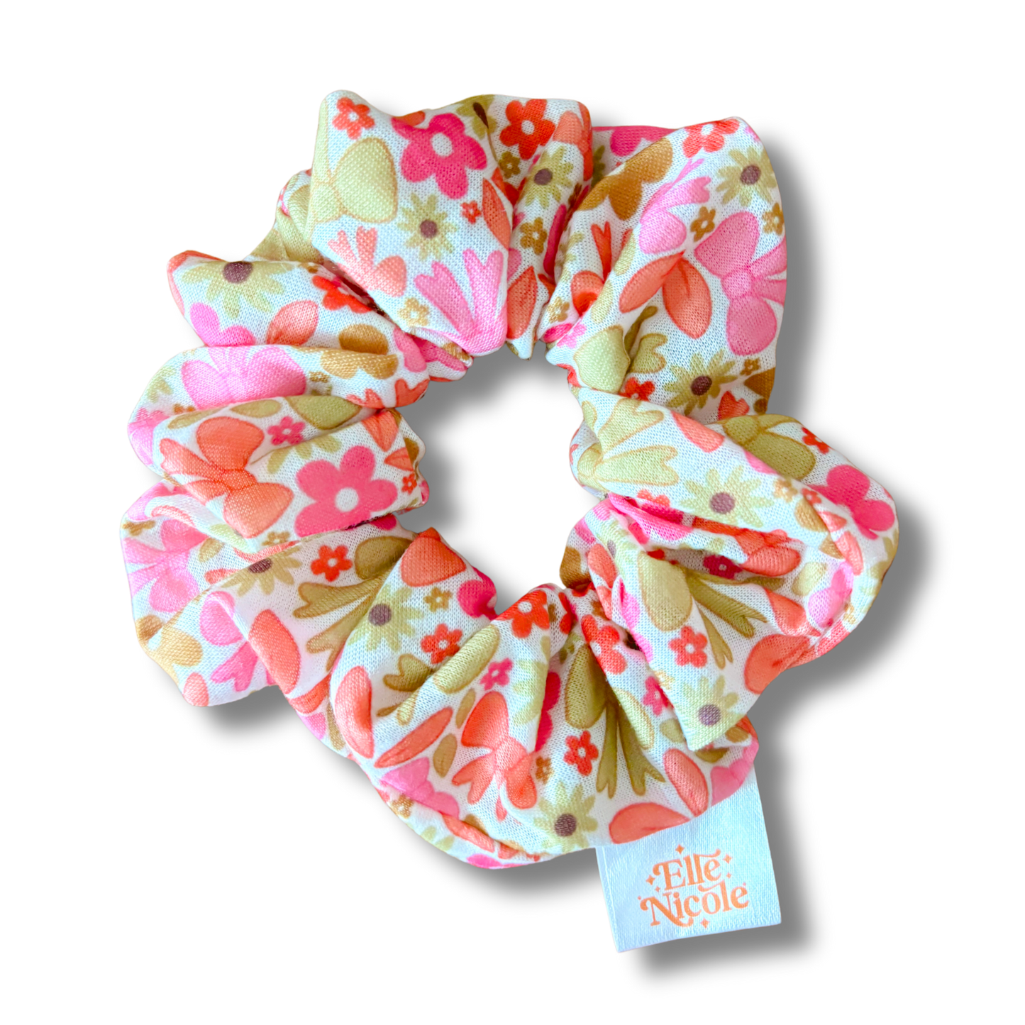 Floral patterned scrunchie with a visible brand tag on a white background