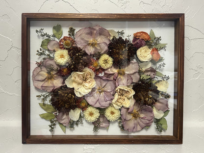 Framed pressed flowers on a textured wall