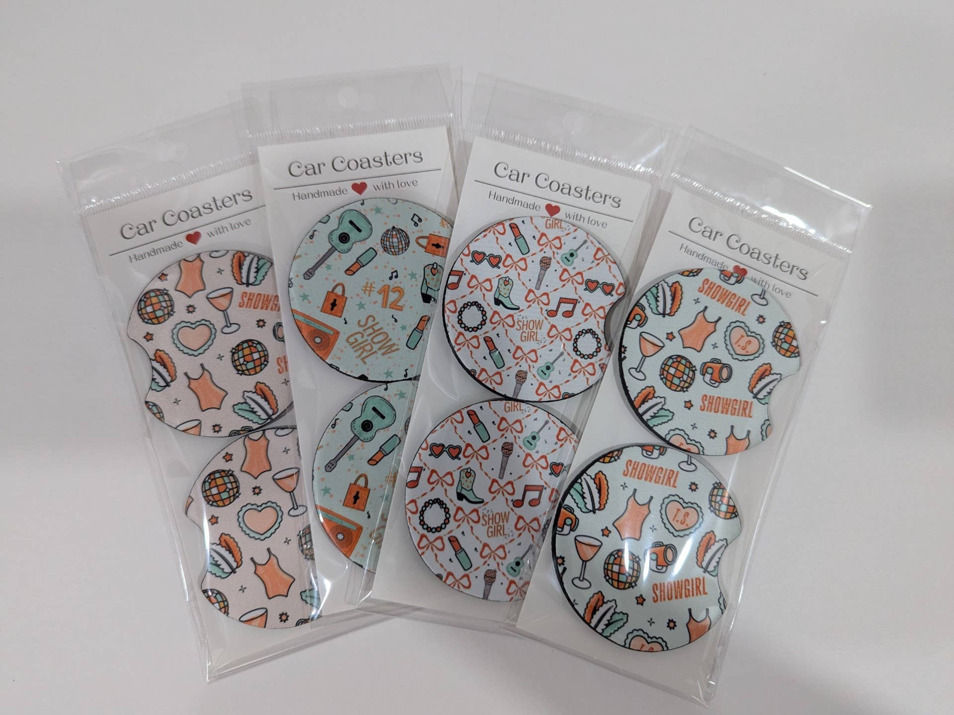 Set of four car coasters in clear packaging on a white background