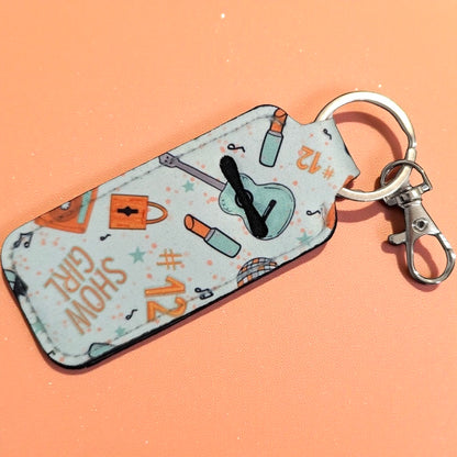 Keychain with a pattern of a clock, backpack, and other items on a peach background