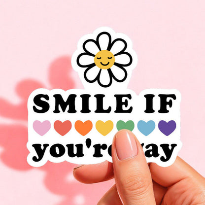 a white sticker that reads smile if you're gay with rainbow hearts across the middle and a white daisy at the top