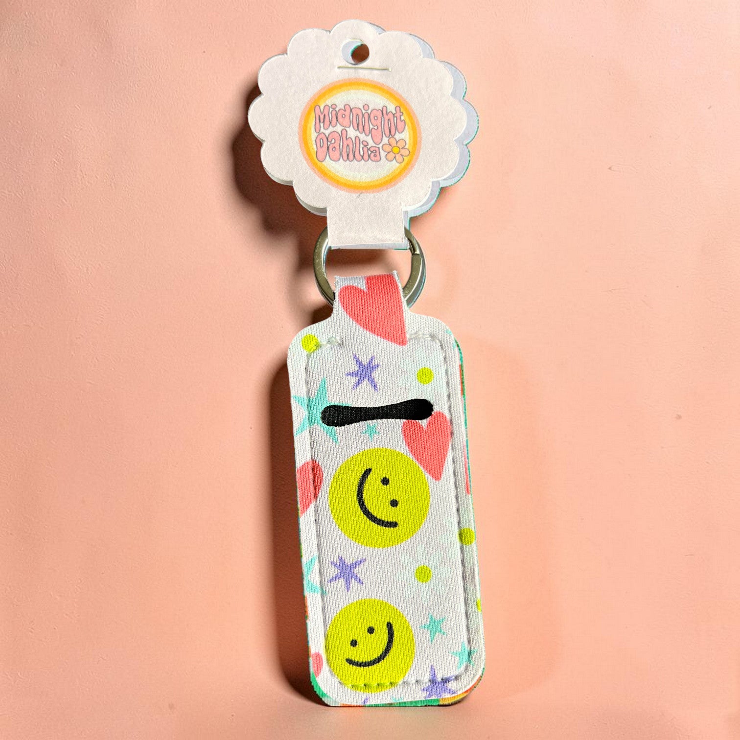 Keychain with smiley face design on a pink background