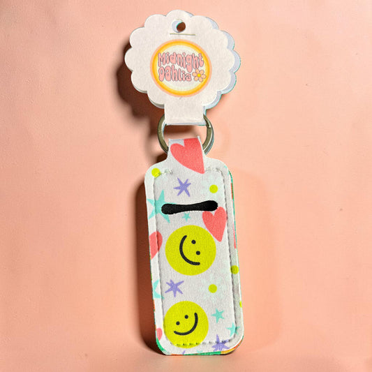 Keychain with smiley face design on a pink background