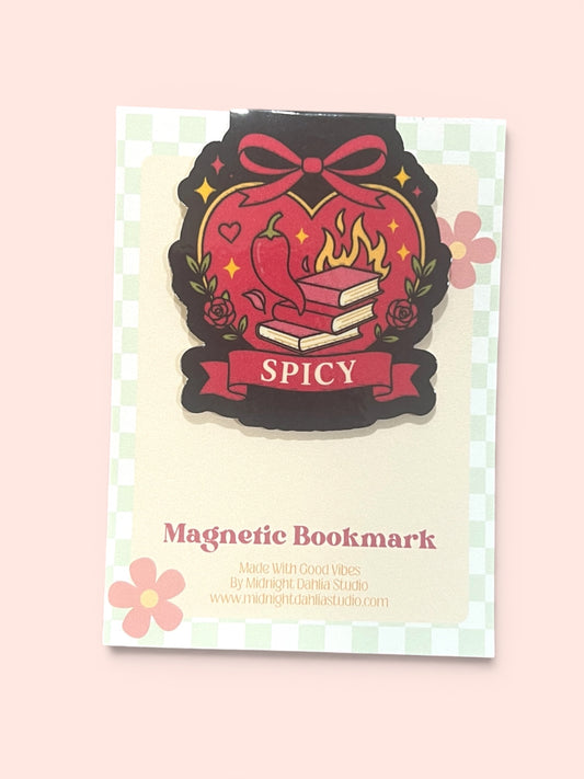 A decorative magnetic bookmark card featuring a stylized red heart, chili pepper, books, and the word 'SPICY' on a pale pink background.