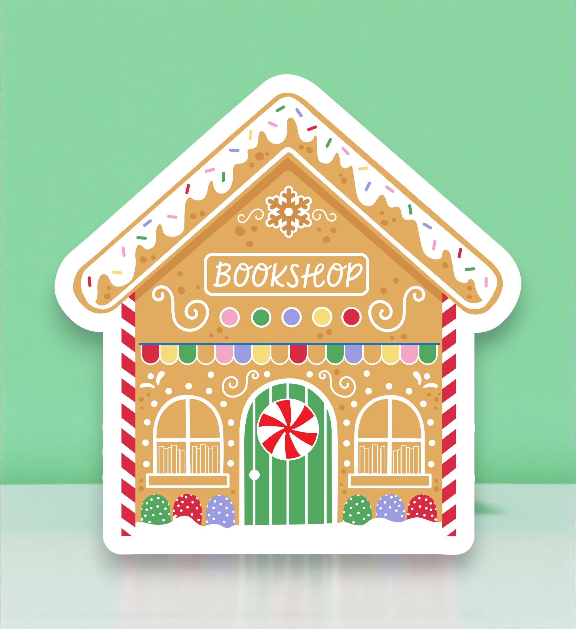 Gingerbread house-shaped bookshop sign with colorful details on a light green background