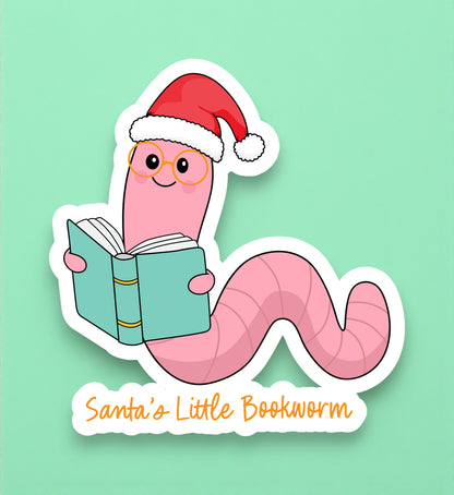 Cartoon worm wearing a Santa hat and reading a book with 'Santa's Little Bookworm' text on a light green background.