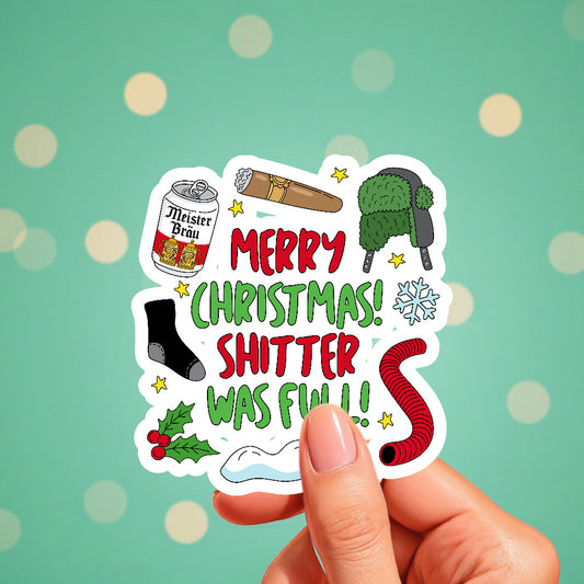 Sticker with Christmas-themed graphics and text held by a hand against a green background with polka dots.