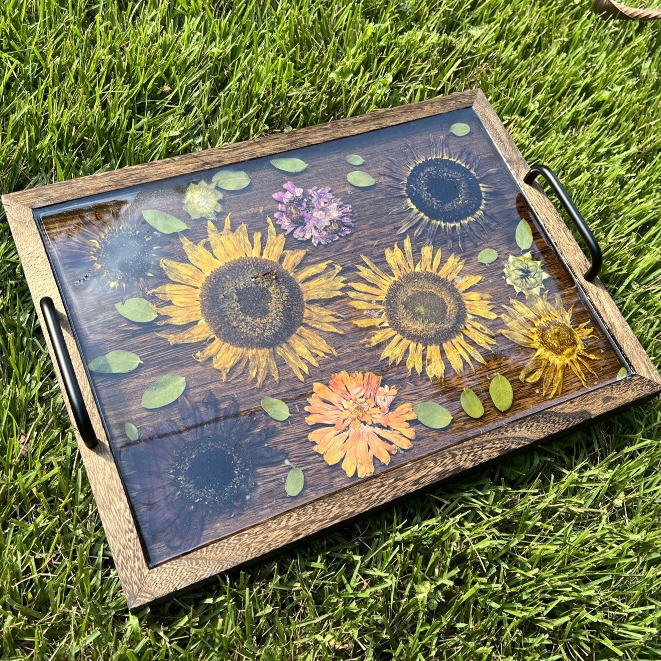 Wooden tray with floral design on grass