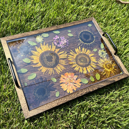 Wooden tray with floral design on grass