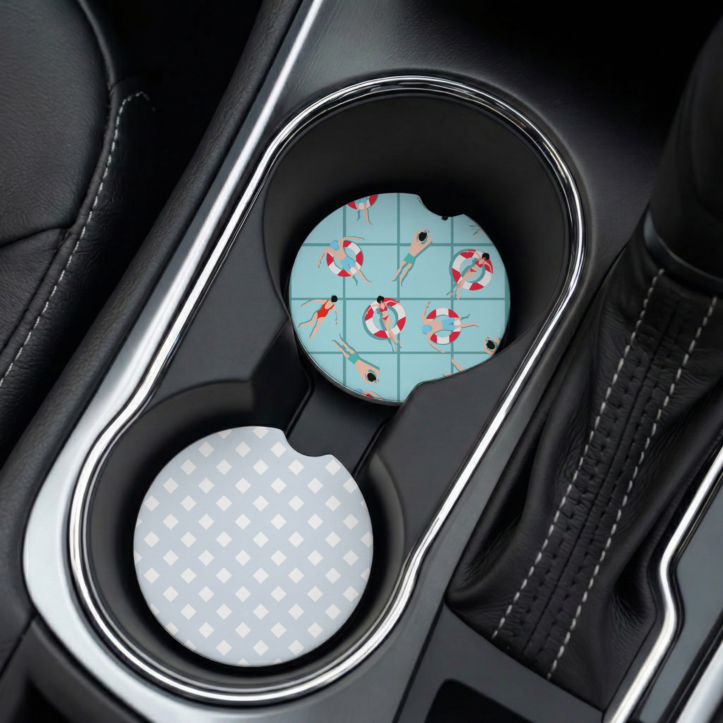 Car cup holder with two coasters, one featuring a swimmer design on a blue background, the other with a checkered pattern.
