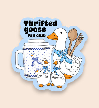Sticker with cartoon geese, a mug, and kitchen utensils with 'Thrifted goose fan club' text on a beige background.