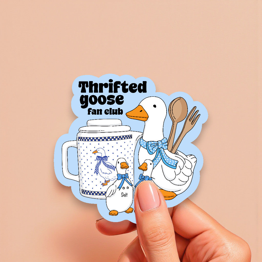 Sticker with 'Thrifted goose fan club' design featuring a duck, mug, and utensils on a beige background.