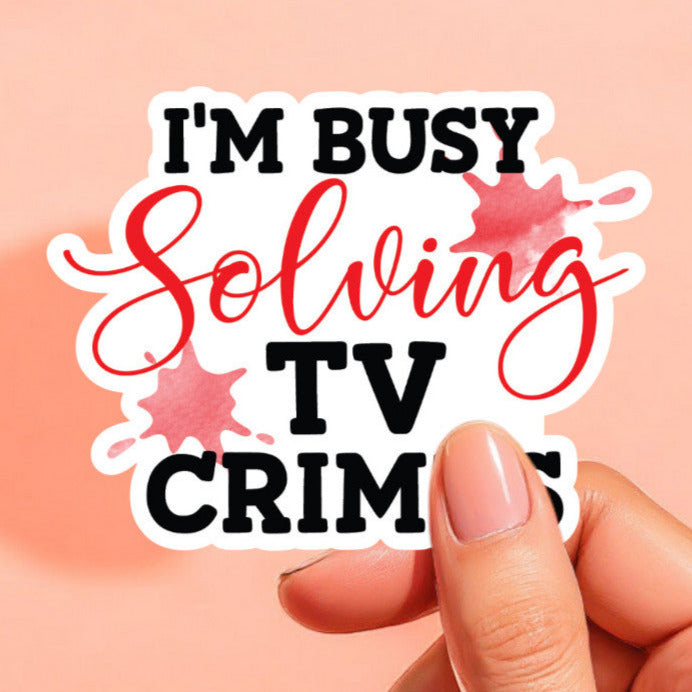 a white background sticker that reads I'm busy solving tv crimes in red and black with red splotches in the background