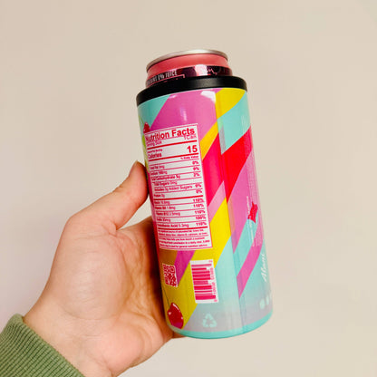 Hand holding a colorful can with geometric design against a plain background