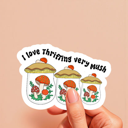 Sticker with mushrooms and text held by a hand on a beige background