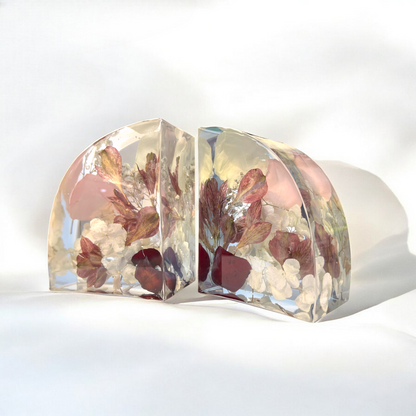 Clear resin bookends with embedded dried flowers on a white background