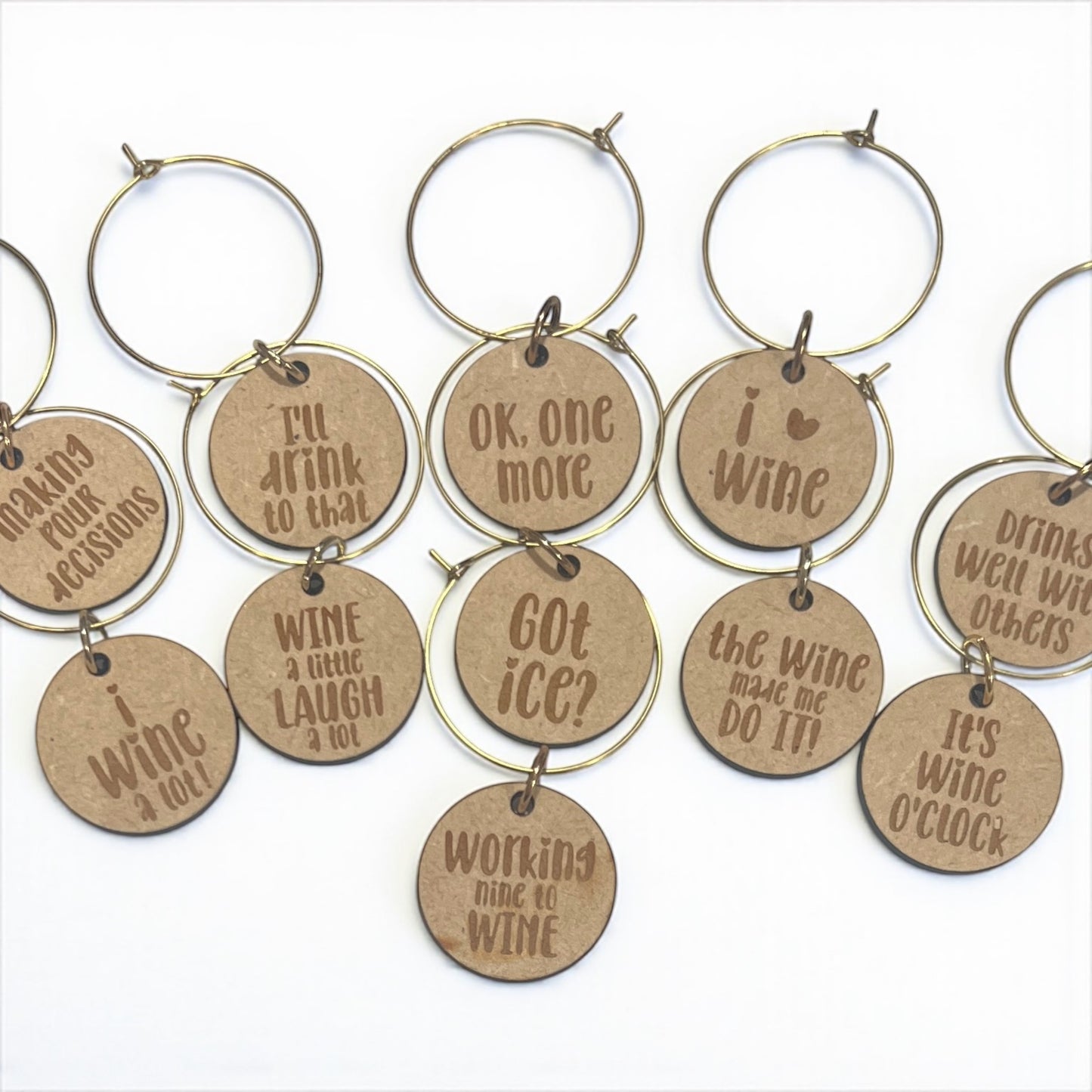 Set of wine glass charms with humorous sayings on a white background