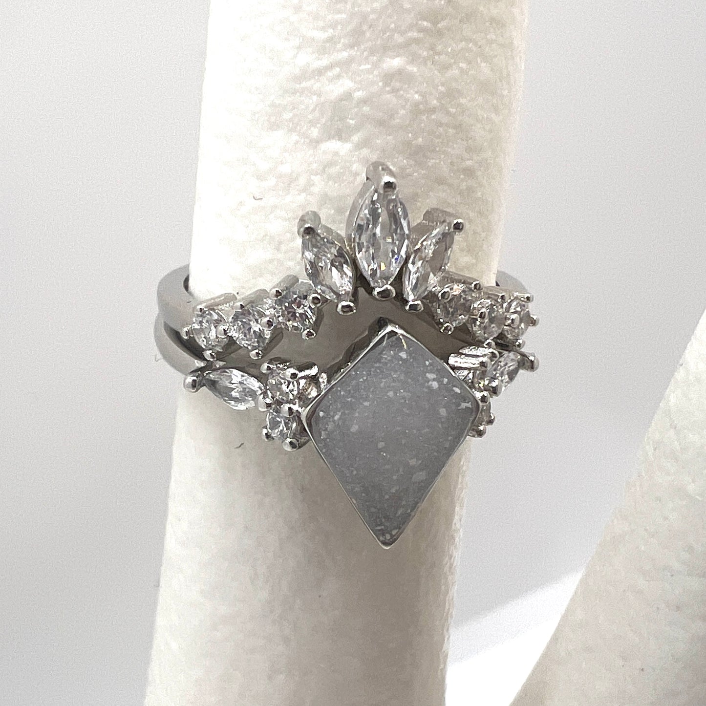 Silver ring with diamond-like stones on a white background