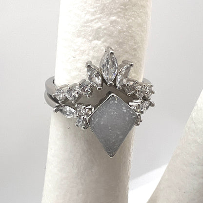 Silver ring with diamond-like stones on a white background