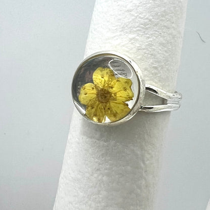 Silver ring with a yellow flower on a white background