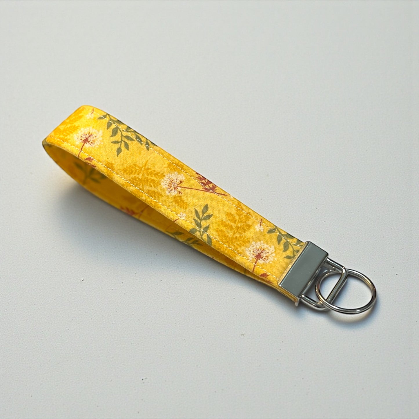 Yellow floral keychain strap on a gray background