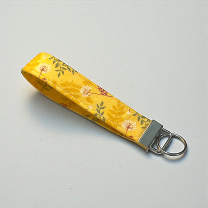 Yellow floral keychain strap on a gray background