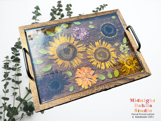 A custom wooden tray filed with orange and purple zinnia and yellow and brown sunflowers .  A beautiful option for bouquet preservation.